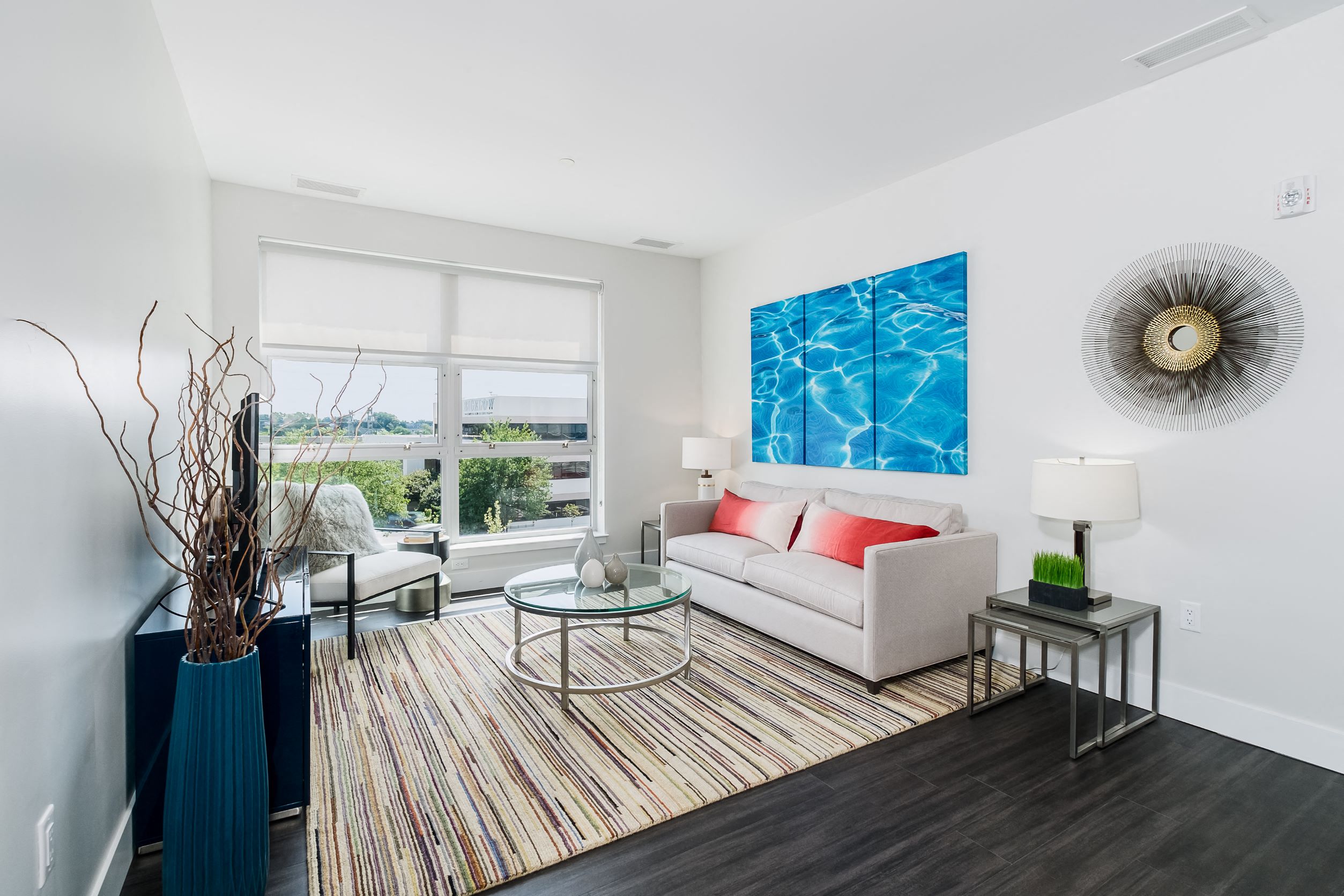 A living room with a couch, a table, and a painting on the wall.