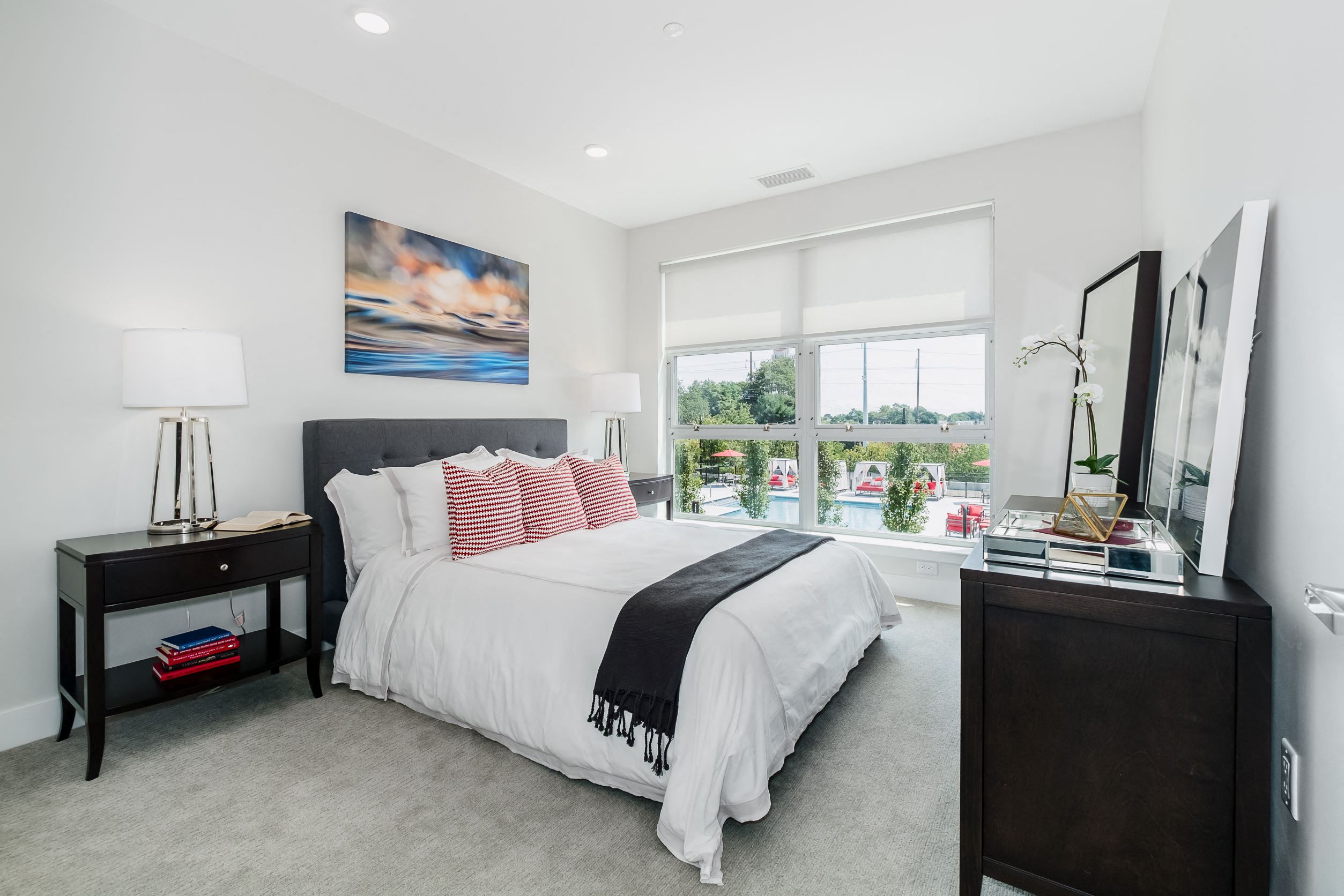 A bedroom with a large bed and a painting on the wall.