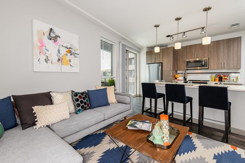 A living room with a grey couch and a coffee table with a glass top.