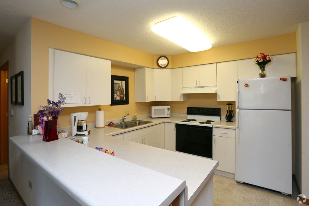 a kitchen with a white counter and a refrigerator