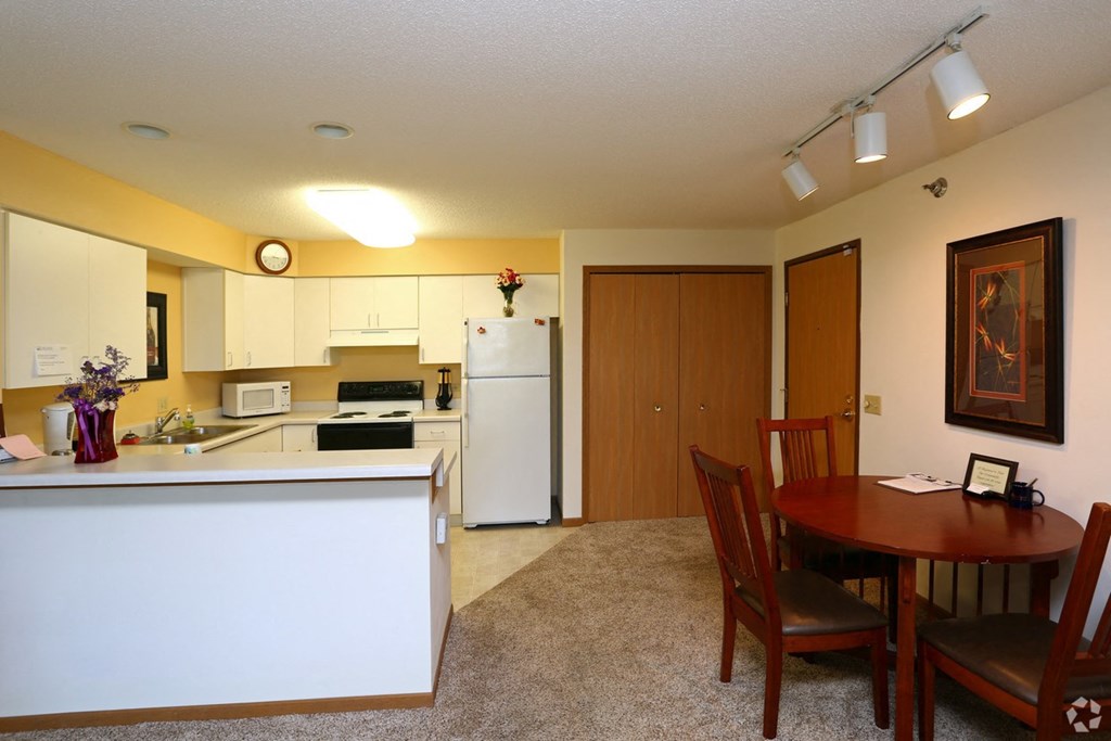 a kitchen and dining room with a table and a refrigerator