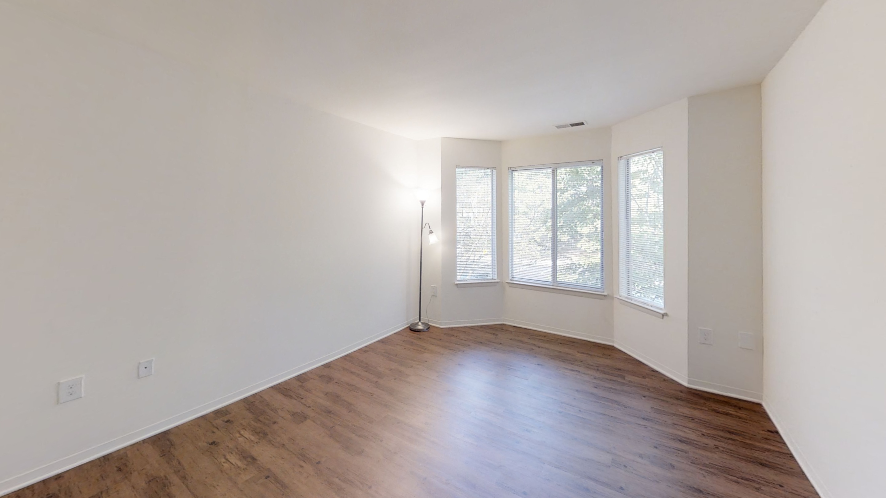 an empty living room with white walls and wood floors