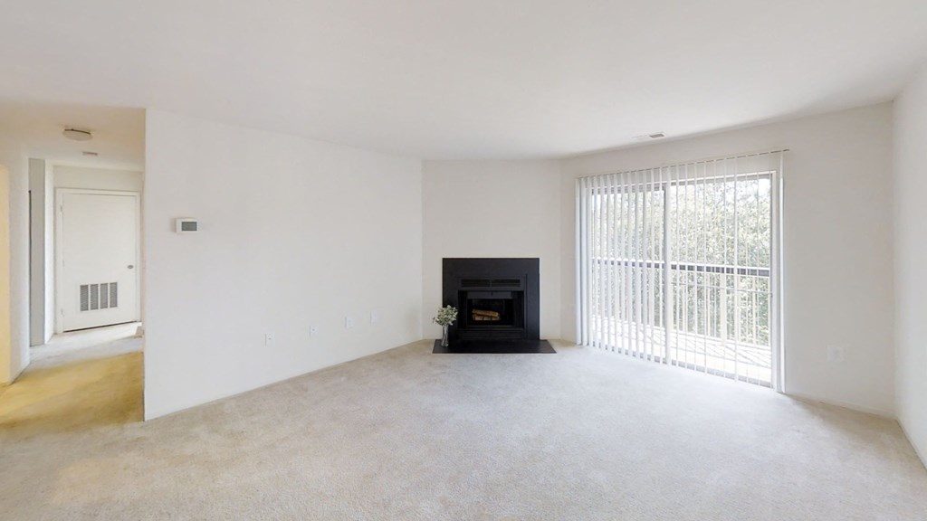 an empty living room with a fireplace and a window