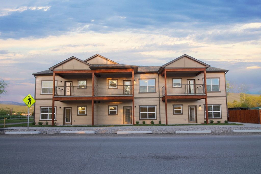 an apartment building with a street sign in front of it