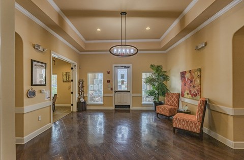 a lobby with chairs and a table and a chandelier