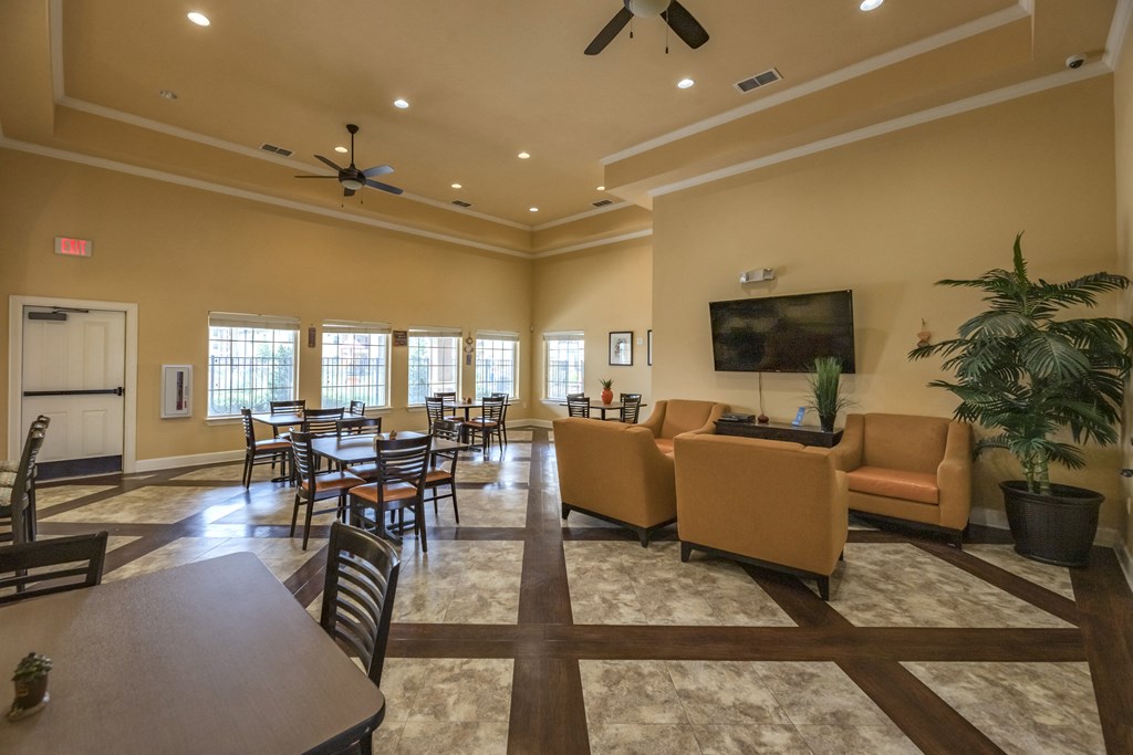 a large living room with tables and chairs and a television