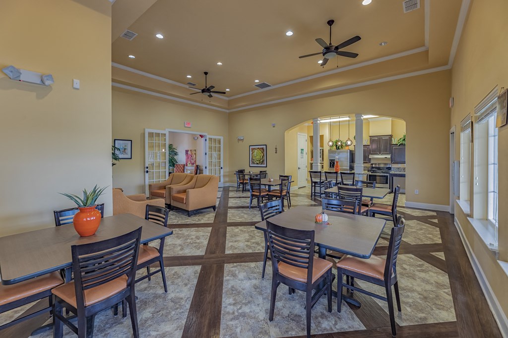 a large dining room with tables and chairs and a kitchen
