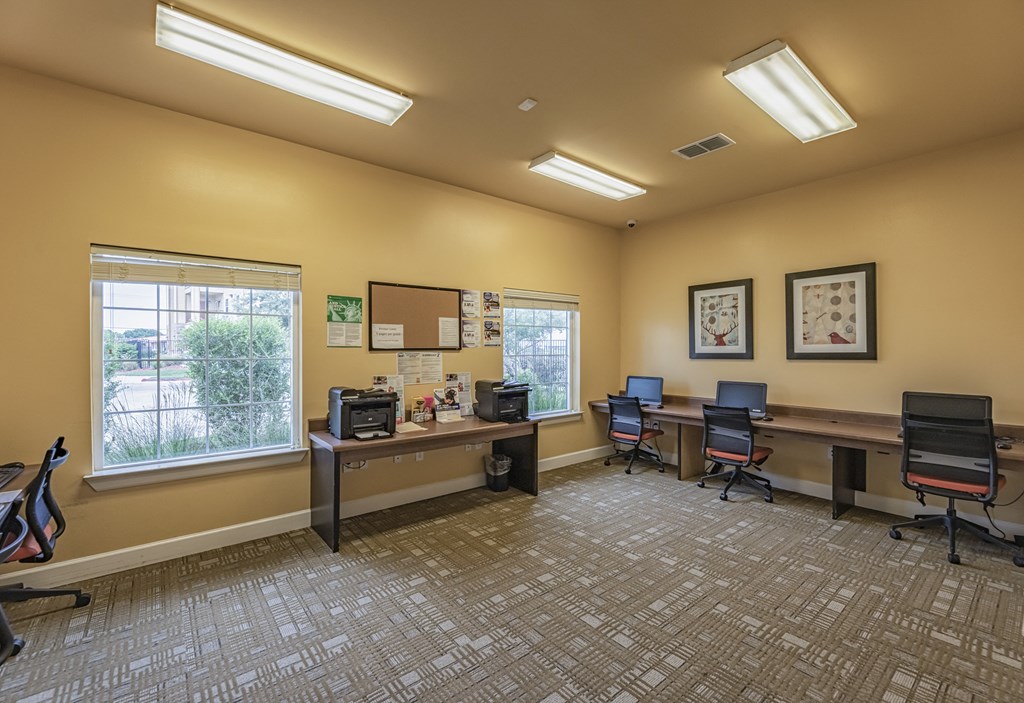 a community room with three computers and two windows