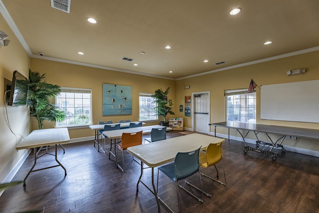 an empty classroom with tables and chairs and a whiteboard