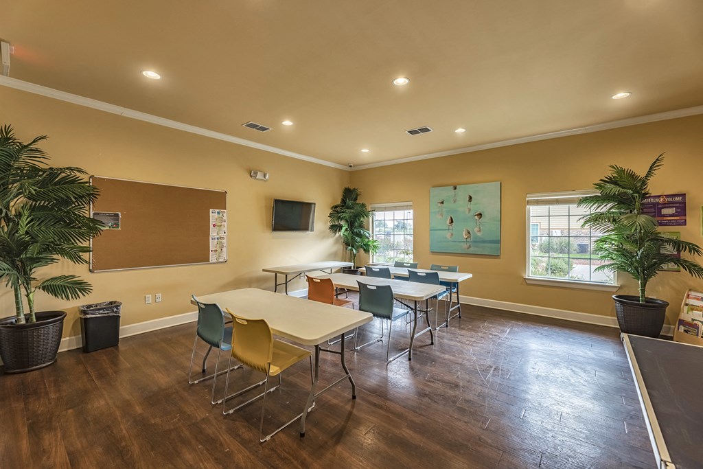 a conference room with tables and chairs and a television