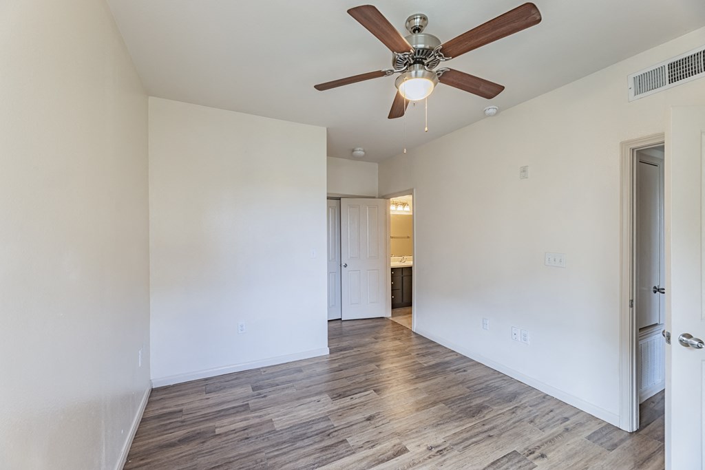 a living room with white walls and a ceiling fan