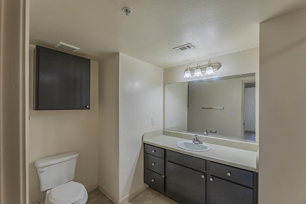 an empty bathroom with a toilet sink and mirror