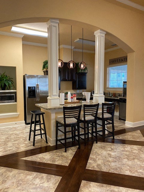 a kitchen with a bar and chairs