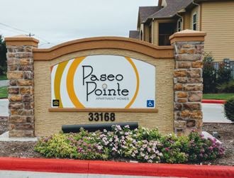 a sign pointe apartments in front of a brick building