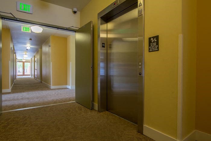 an empty hallway with elevators and doors in a building