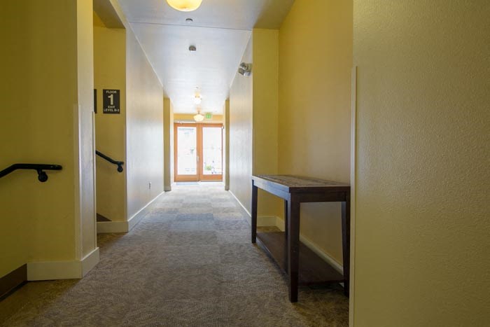 a hallway with yellow walls and a wooden table