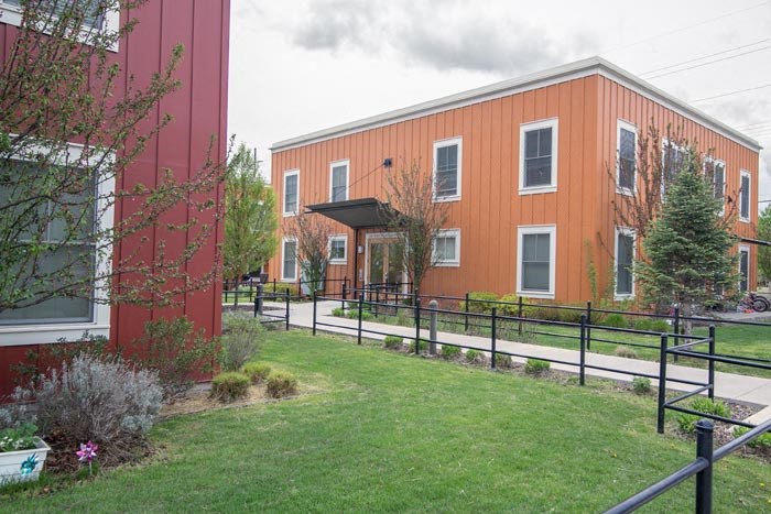a large red building with a green yard in front of it