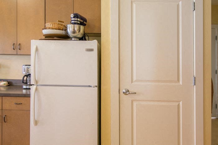 a white refrigerator in a kitchen next to a door