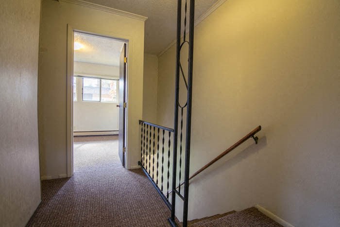 a hallway with a staircase and a door to a room