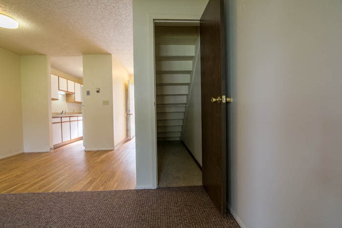 an empty room with a staircase and a door open