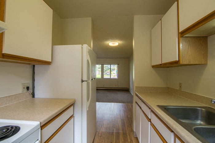 an empty kitchen with a sink and a refrigerator