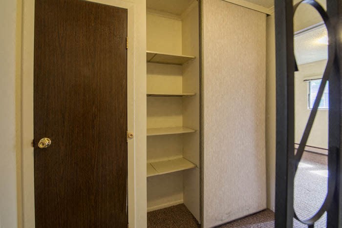 a small closet with shelves and a door