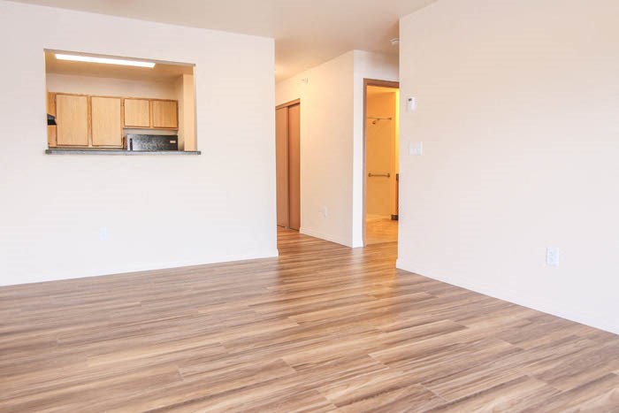 a living room with a hard wood floor and a kitchen