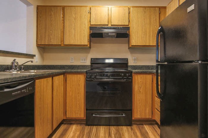 a kitchen with black appliances and wooden cabinets