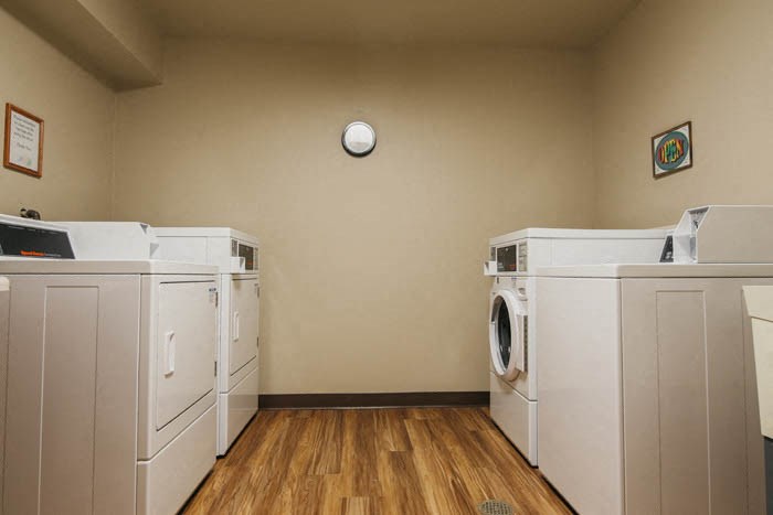 an empty laundry room with four washer and dryers