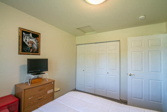a small bedroom with a bed and a television