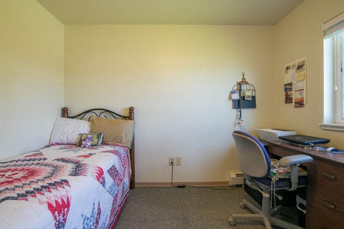 a bedroom with a bed and a desk with a chair