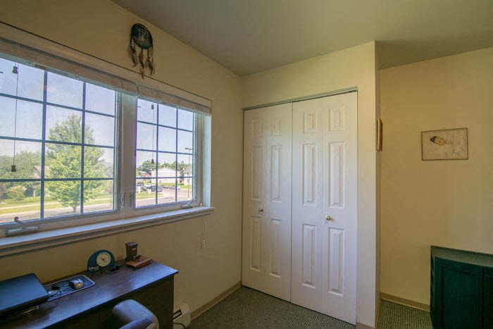 a room with a desk and a window and a door