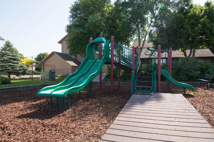 a playground with slides and a wooden deck