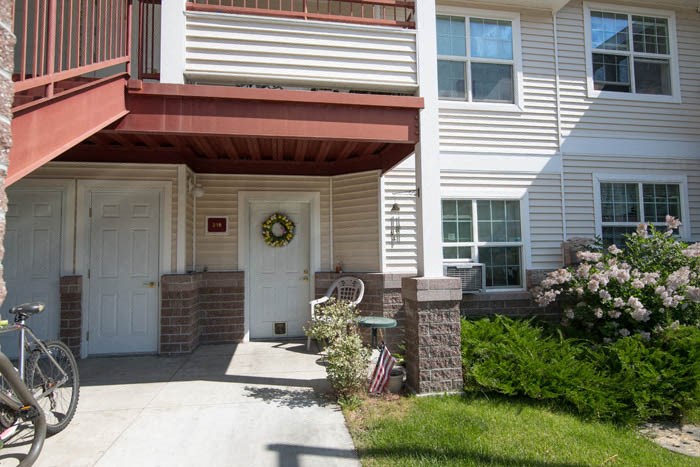 a white house with a porch and a wreath on the door