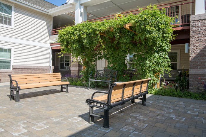 two benches on a patio in front of a building