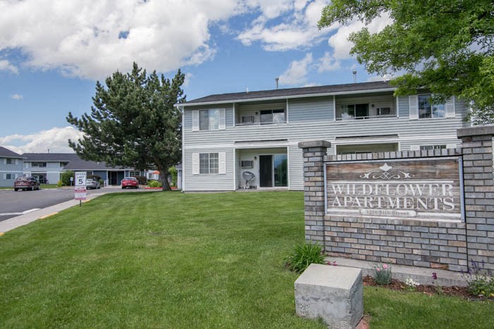 an apartment building with a sign in the grass