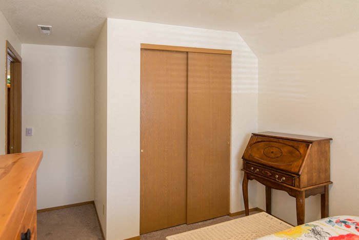 a bedroom with a dresser and a closet