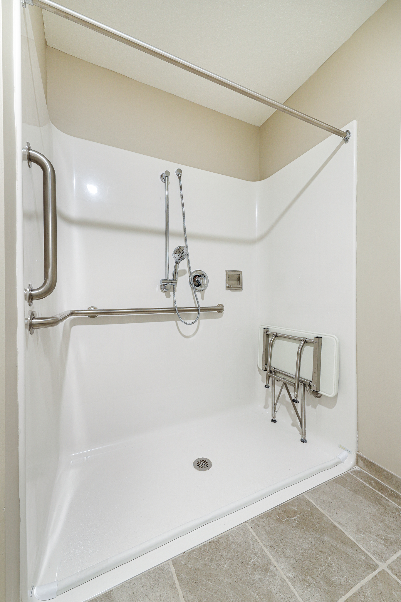 a bathroom with a shower and a wheelchair rail in it