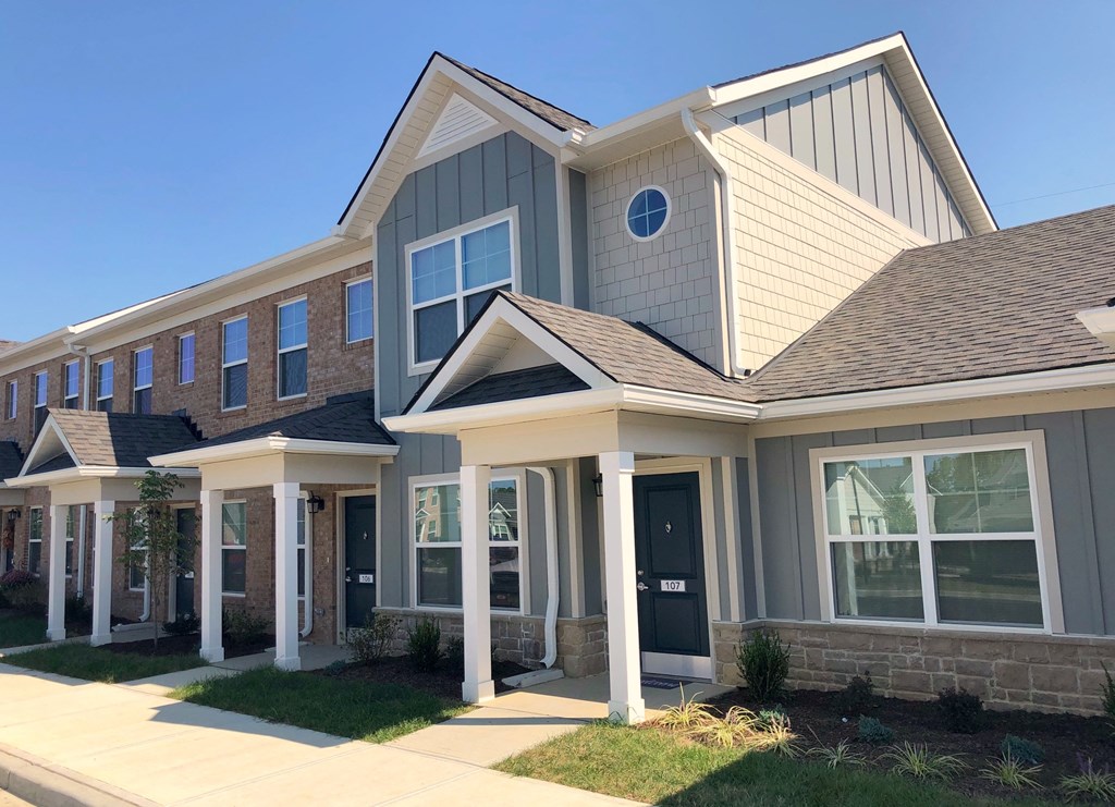 a row of houses with a sidewalk in front of them
