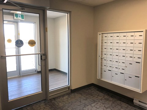 a locker room with a door and some mailboxes on the wall