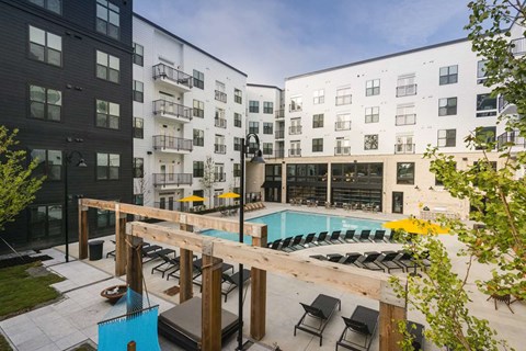 a communal pool area with an apartment building and a pool