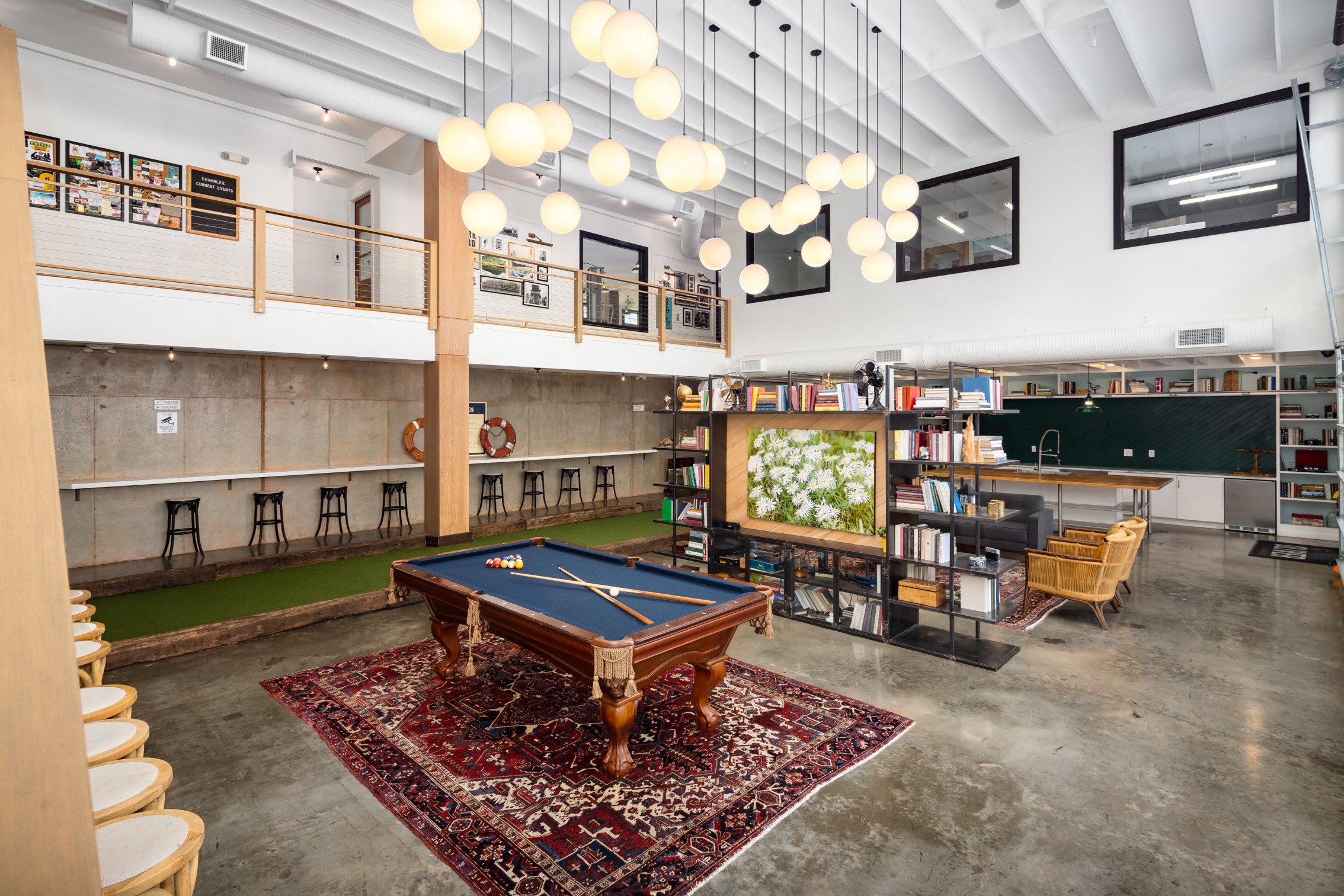 a recreation room with a pool table in the middle of it