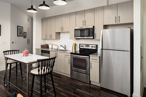 a kitchen with stainless steel appliances and a white table and chairs