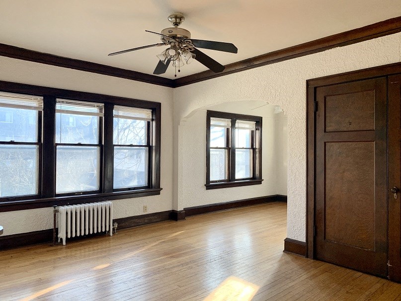 a living room with a ceiling fan and a wood floor