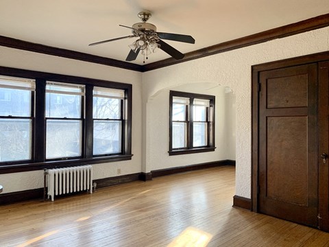 a living room with a ceiling fan and a wood floor