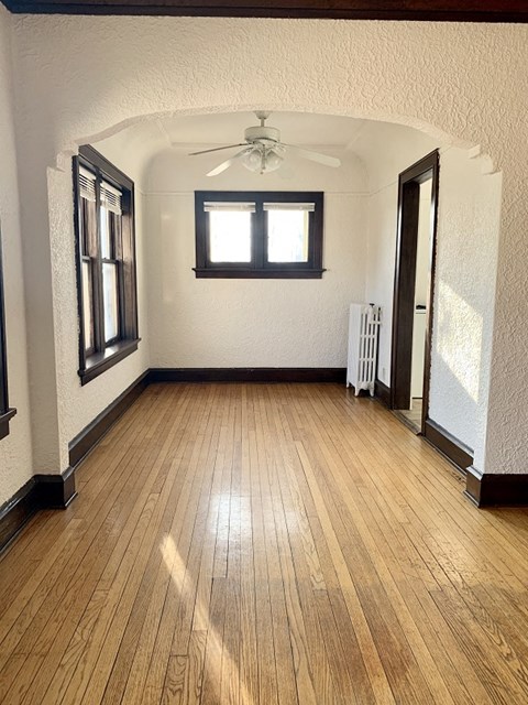 a living room with a hard wood floor and a ceiling fan