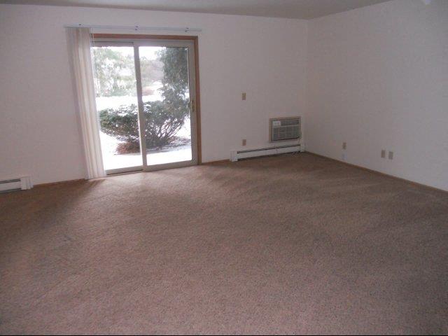 an empty living room with a door to a patio