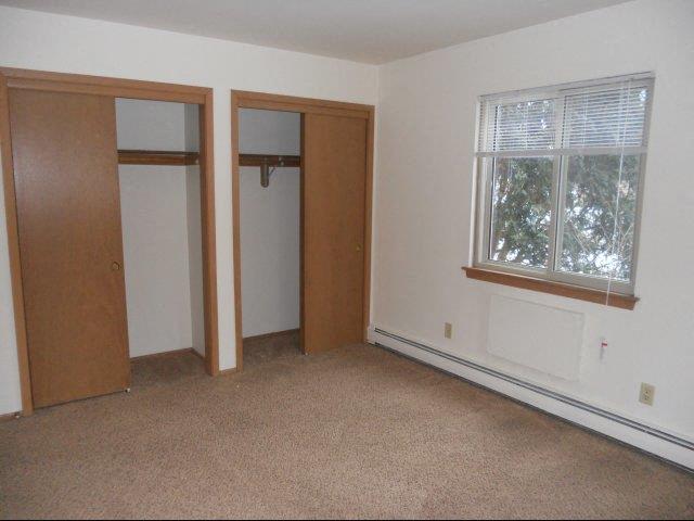 an empty room with a window and two doors