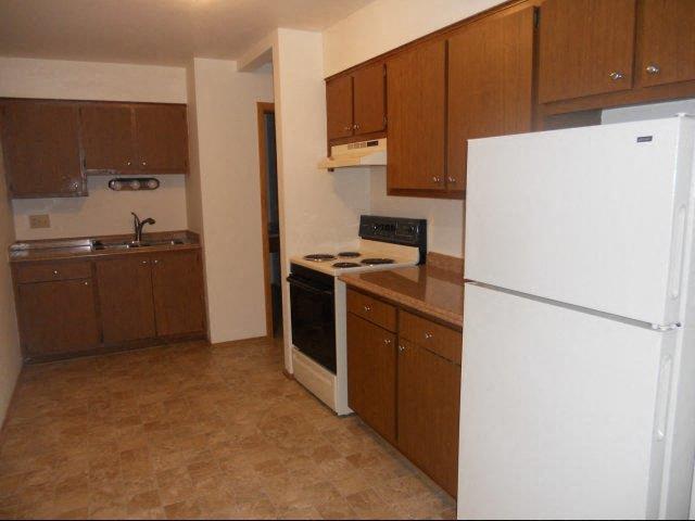 a kitchen with a white refrigerator and a stove