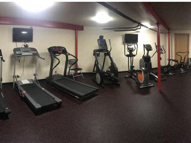a workout room with a lot of exercise equipment
